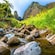 A rocky ravine running through a lush, mountainous landscape in Maui